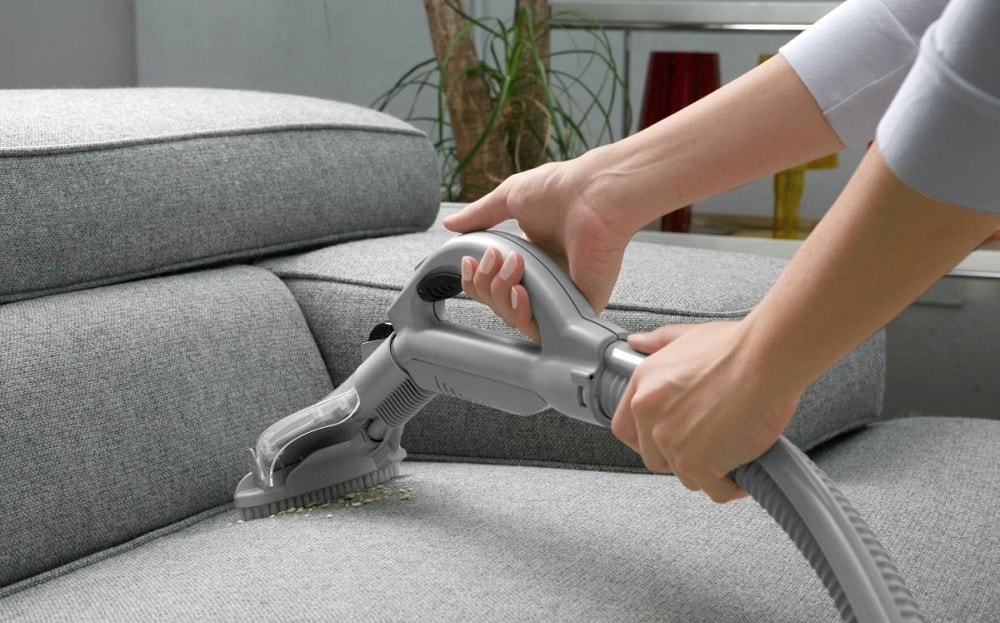 Чистка обивки дивана пылесом.